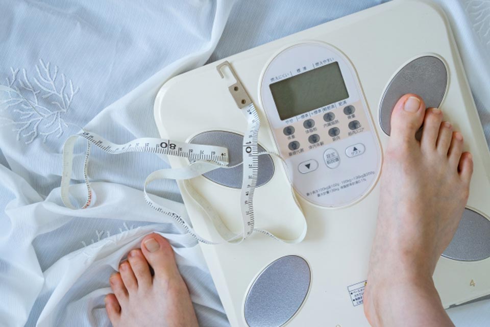 更年期の女性が体重を測定しているイメージ
